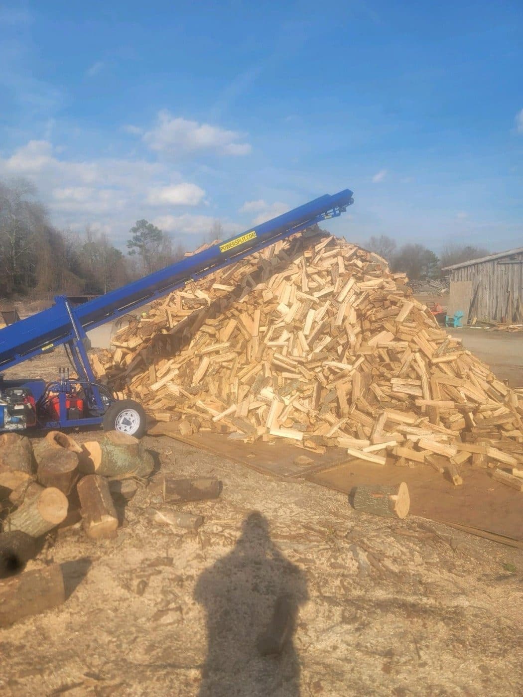 Conveyor on the Tree Works firewood processor stacking split wood